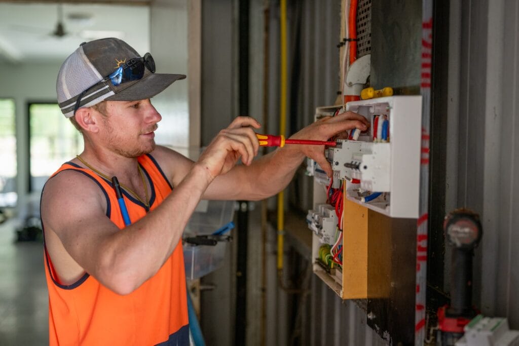 switchboard during a solar installation in Darwin, NT Eco Tech Electrical technician working on a switchboard during a solar installation in Darwin, NT